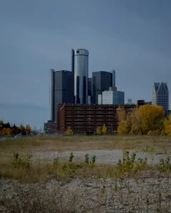 Vacant lot in forefront with Detroit high-rises in the background